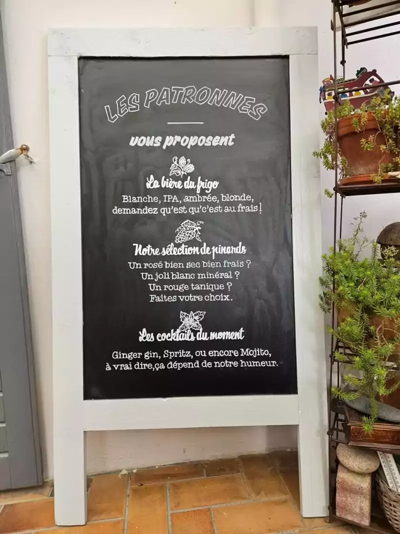 Ardoise du bar à vins Les Patronnes installée devant l'établissement, lettering blanc peint à la main